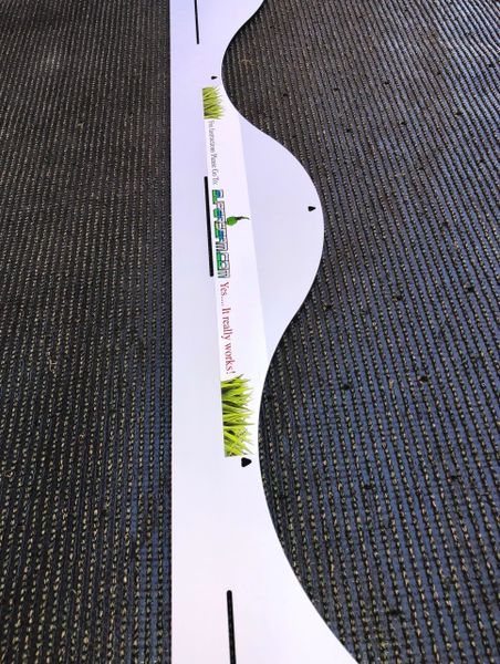 A white ruler with green lettering on it.