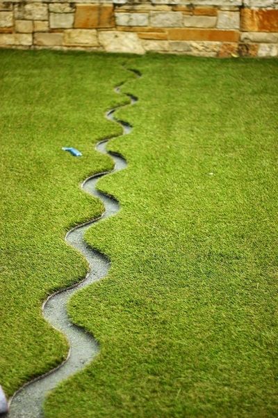 A line of grass with water running down it.