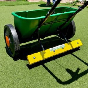 A green lawn being mowed with a yellow and black cart.