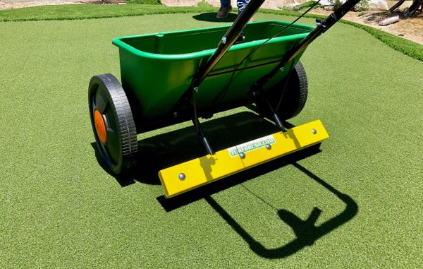 A green lawn being mowed with a yellow and black cart.