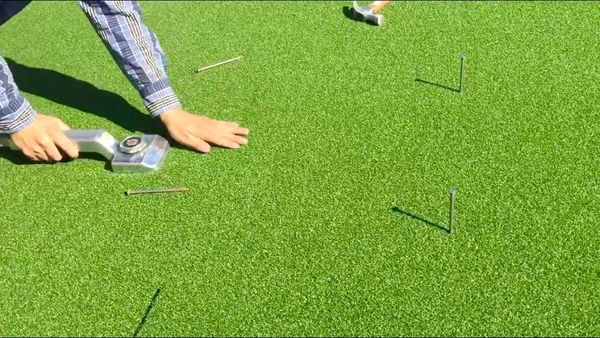 A person is playing golf on artificial grass.